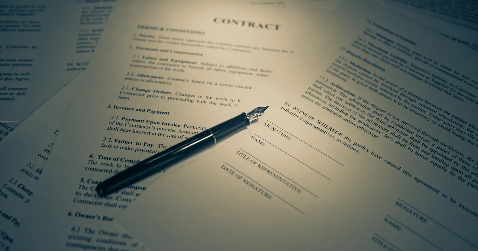 Una penna stilografica posata su un contratto stampato, aperto alla pagina delle firme
